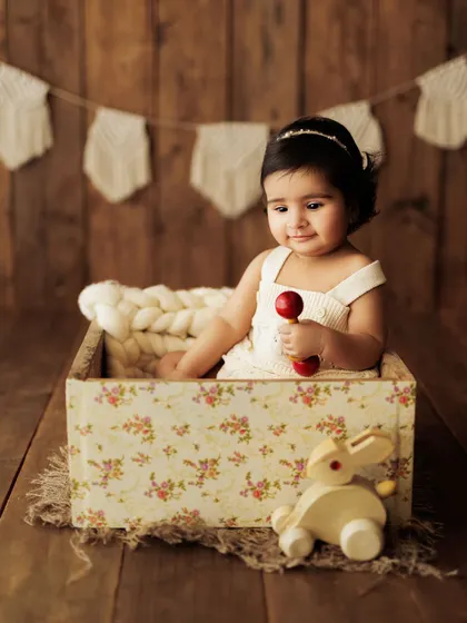 A sweet, contemplative moment from a sitter session. The vintage-style floral box and wooden rabbit toy add a touch of timeless charm.