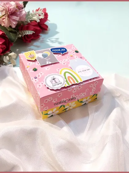 A mini hamper box created for a best friend's birthday, filled with chocolates, photos, and handmade cards.