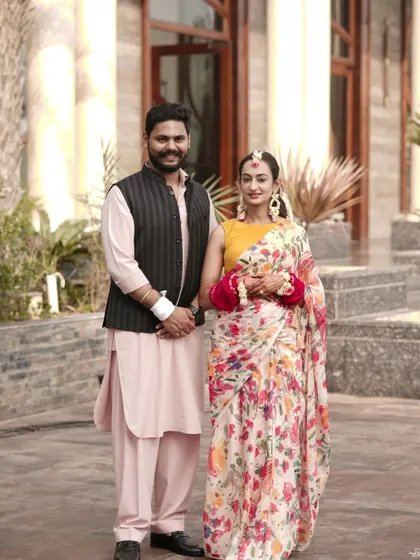 A classic portrait of the couple in their Haldi attire. The groom in his kurta and Nehru jacket complements the bride's beautiful floral saree.