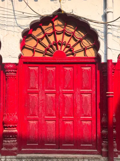 The vibrant red of this door stands out against the old walls, a perfect example of the photogenic character of Chandni Chowk's hidden lanes.