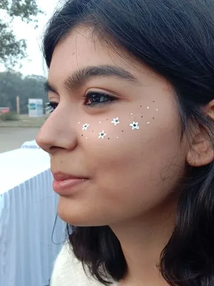 A sprinkle of tiny white daisies across the cheek. This is a sweet, simple, and very popular design.