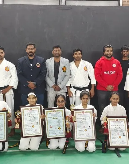 Our senior students and black belts posing with their well-earned certificates and trophies after a successful belt grading event.