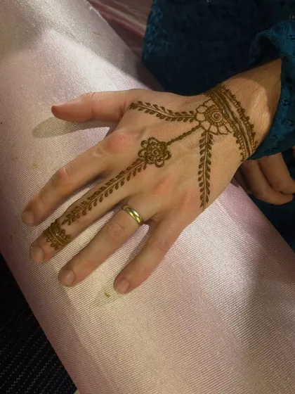 A classic "hathphool" or jewelry-style mehendi design. This pattern mimics a hand chain and is a very popular choice for bridesmaids and guests.