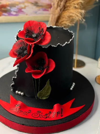 A sophisticated black cake with a fault line design and delicate red poppy flowers. The "Best Sister" banner makes it a perfect, stylish birthday gift.