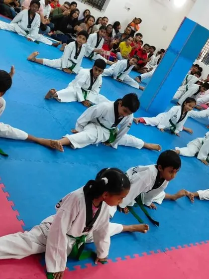 Students work on their splits during a belt exam warm-up.
