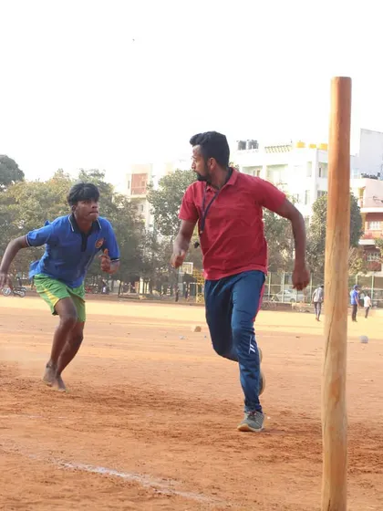 A chaser in hot pursuit of a defender near the pole. This shows the raw speed and determination required in a competitive Kho-Kho match.