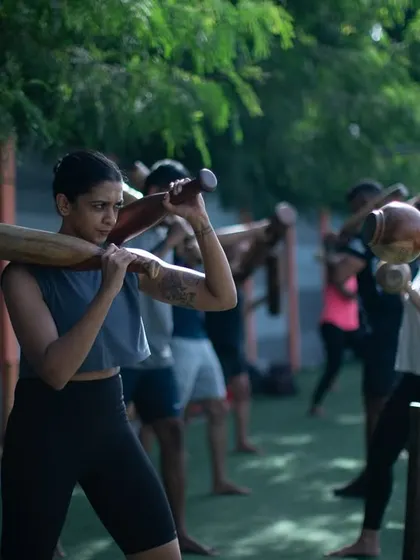Women training together, barefoot on the turf, using traditional Mudgars. This image captures the essence of our community: authentic, grounded, and strong.