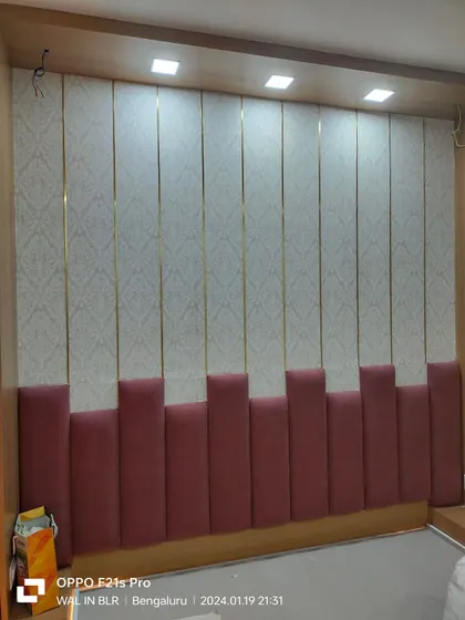 Wallpaper installed in vertical panels with gold trim, creating a very luxurious and custom headboard wall.