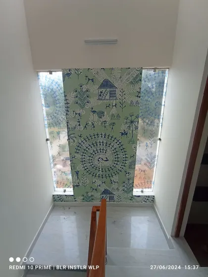 A Warli art-style mural installed on a narrow staircase wall. This traditional Indian folk art adds a unique cultural element to the home's decor.