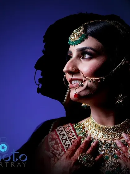 An artistic bridal portrait using a silhouette effect against a blue background, creating a modern and striking image.