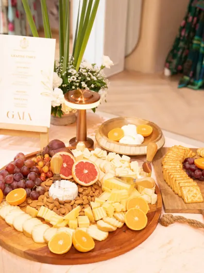 A bright and sunny cheese board created for a Gaia brand event. The platter is loaded with a variety of cheeses, almonds, crackers, and fresh citrus fruits like grapefruit and orange.
