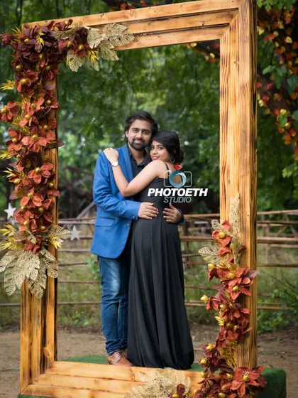 A creative pre-wedding portrait using a large, empty picture frame as a prop. It’s a fun way to frame the couple and add a unique element to their outdoor shoot.