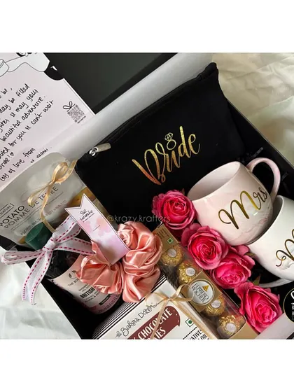 A gorgeous 'Bride to Be' hamper featuring 'Mr & Mrs' mugs, a personalized pouch, Ferrero Rocher chocolates, and fresh roses.