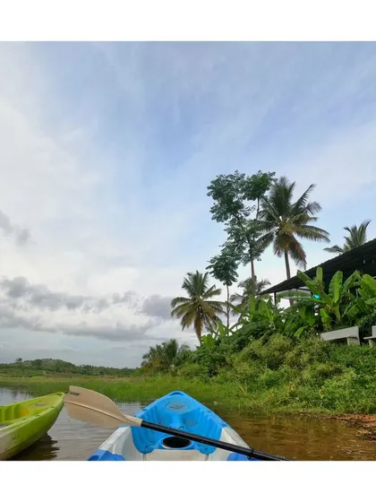 A view from the kayak, showing another boat nearby and the green shoreline of our camp.