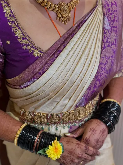 A close-up of the saree drape, showing the neat pleats and how the jewellery, including the vaddanam and bangles, complements the overall look.