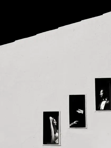 This award-winning shot is all about minimalist composition. I used the stark lines of the building and the small windows to create a story of connection and distance, proving that powerful portraits can be found in the simplest of elements.
