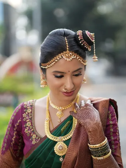 A close up on the makeup and hair details. Note the intricate matha patti and the soft, blended eyeshadow.