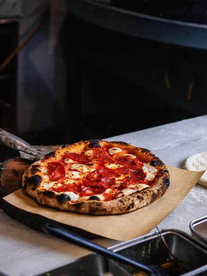 A classic pepperoni pizza, fresh from the oven, sits on the counter. A perfect representation of my commitment to delicious, high-quality food, any day of the year.