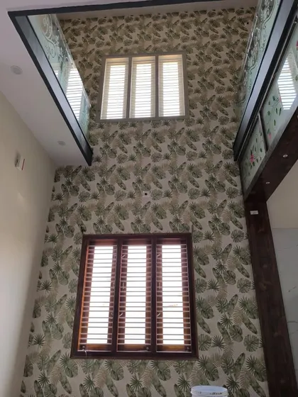 A double-height wall covered in a green leaf pattern, creating a stunning vertical effect in a modern home.