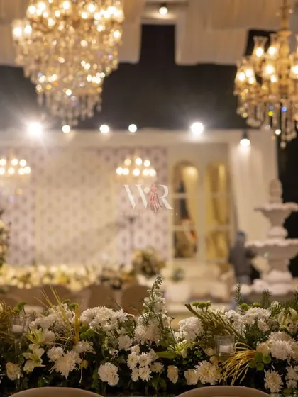 A symphony in ivory, mogra, and crystal. This close-up shows the layers of white florals and the soft glow of chandeliers, creating a serene and luxurious atmosphere.