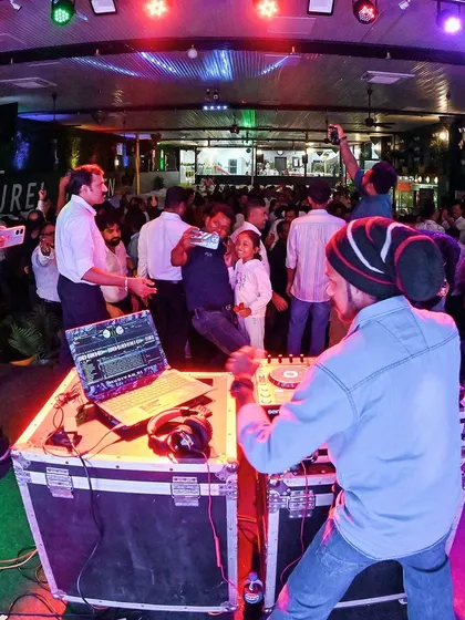 A view from behind the DJ booth, showing the entire party in full swing.