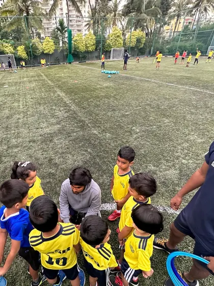 A coach kneels down to talk to his team. We believe in connecting with our players on a personal level.