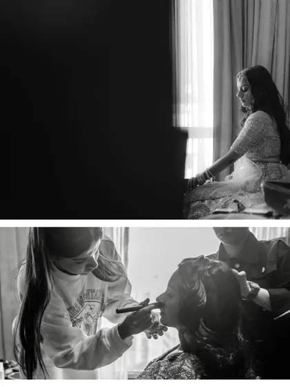 A behind-the-scenes look at the bridal preparation, captured in black and white. It shows the makeup artist at work, creating a documentary-style feel.