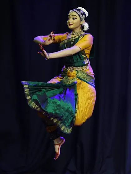 A mid-air leap captured during the Ninada Nruthyotsava, showcasing the athleticism and energy of the dance form.