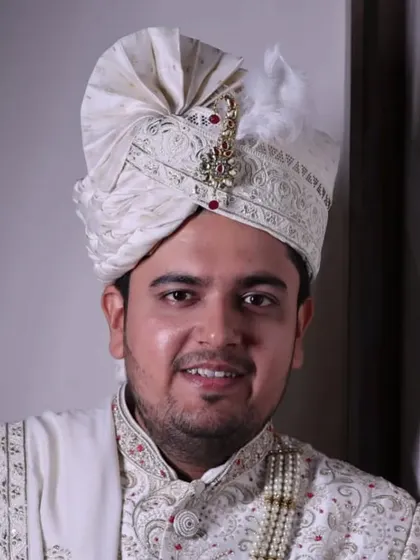 A portrait of the groom looking confident and happy. The natural makeup finish ensures the skin looks healthy and radiant.