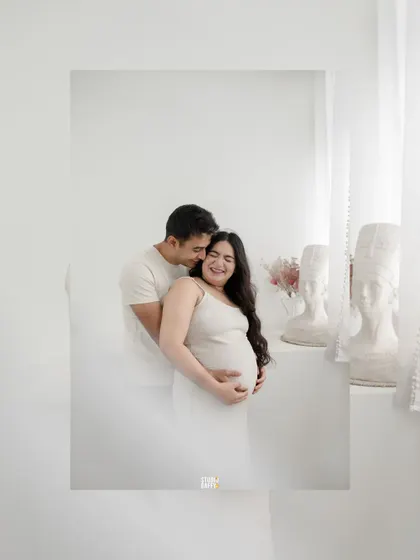 A joyful and candid moment between the expectant couple, filled with laughter and love.