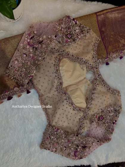 A contemporary blouse design with sheer, embroidered long sleeves and a stylish back cutout.