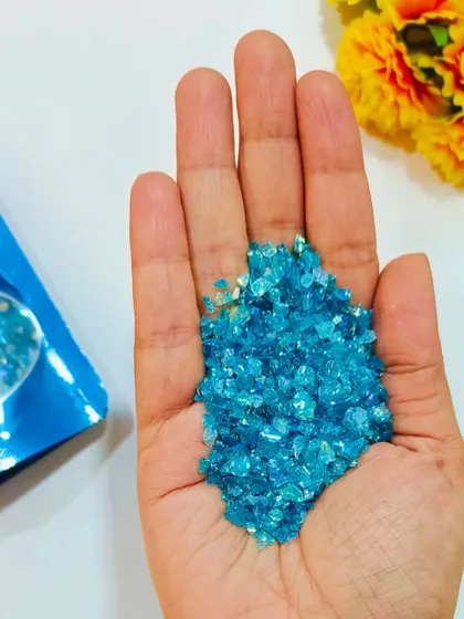 This handful of light blue holographic glass granules shows their brilliant shine. Use them to create stunning ocean effects or add a crystal-like finish to your resin projects.