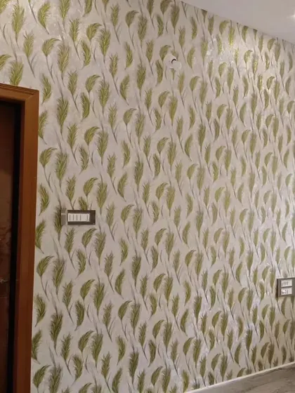 A simple green feather pattern wallpaper adds a fresh and natural touch to this bedroom wall.