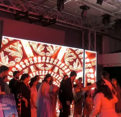 The LED screen shows beautiful traditional patterns, matching the wedding theme.