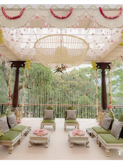 A closer look at the 'Pastel Panchangam' mandap seating. The combination of olive green upholstery with traditional silvered low tables and floral arrangements creates a perfect fusion of modern comfort and classic elegance.