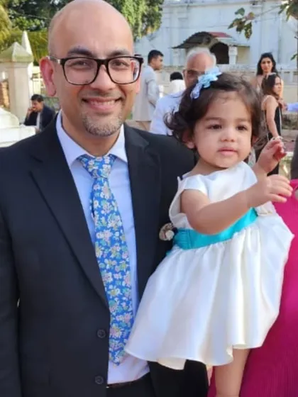 A precious moment captured at a wedding. This little one is wearing a simple yet elegant white satin dress with a bright blue sash, showing how I can customize dresses for any event.