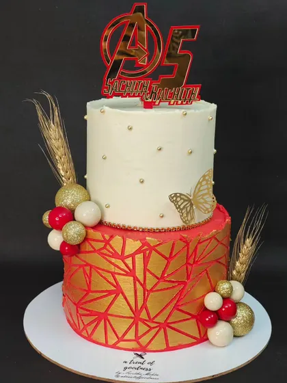 An Avengers-themed cake with a touch of elegance. I used a bold red and gold geometric pattern for the bottom tier and kept the top tier simple to make the Avengers "A" logo pop.