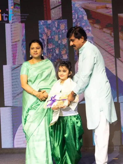 A girl accepts her graduation certificate, her time at Smiti having prepared her for future success.