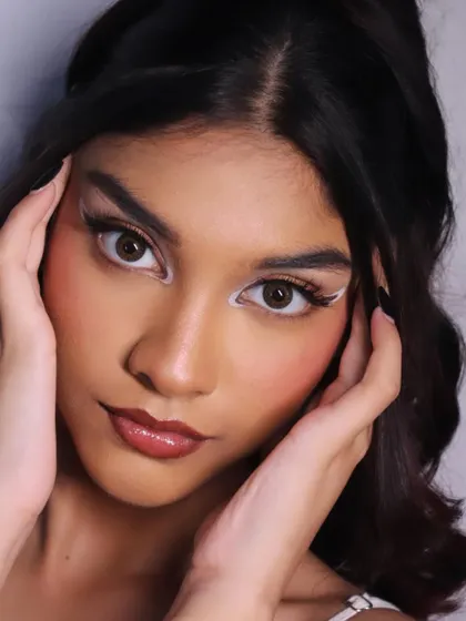 A direct, confident pose that lets the bold eye makeup take center stage.