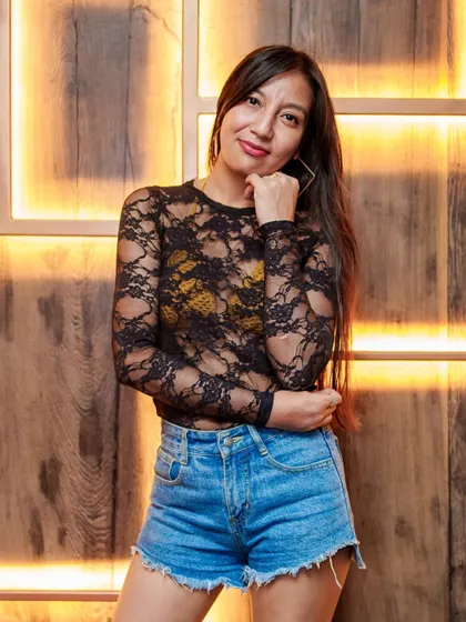 A guest posing against the signature wooden walls of Kaze, a popular photo spot.