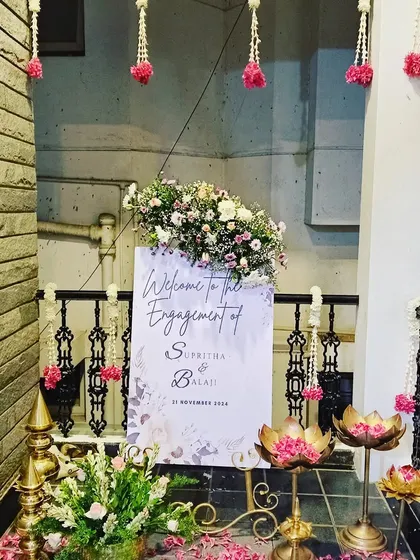 An elegant welcome sign for an engagement, decorated with flowers and traditional lotus-shaped lamps.