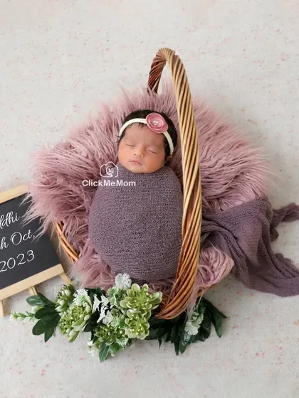 This portrait includes a personalized touch with a small chalkboard announcing the baby's name and birth date, making it a perfect birth announcement photo.