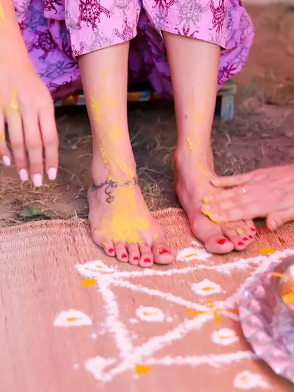 Another perspective on the Haldi ritual, focusing on the hands applying the turmeric paste. These detail shots help to build a complete visual story of the ceremony.