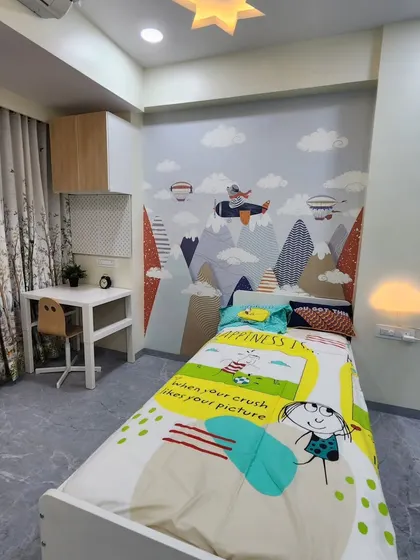A view of the bed and the adventure-themed wallpaper.