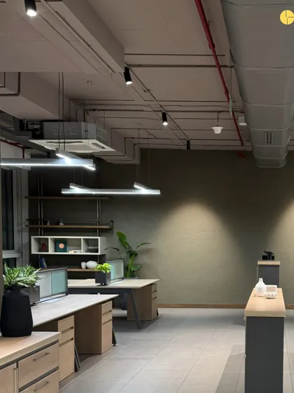 The general workstation area in 'Project LH.' The open-plan layout is designed to be flexible, with exposed ceilings and ductwork adding to the industrial-chic aesthetic. The color palette is kept neutral and calming to promote focus.