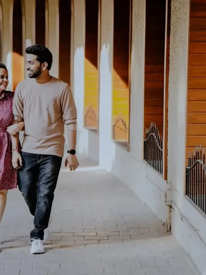 A happy, walking shot through a sunlit corridor, capturing the couple's easy-going chemistry.