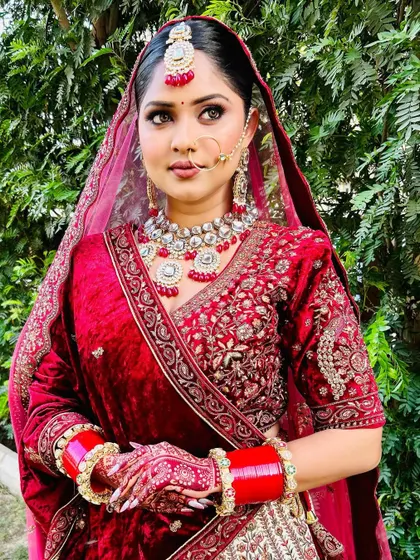 A full portrait of a bride in her magnificent maroon velvet lehenga. My styling ensures the heavy outfit is draped for both beauty and comfort, allowing her to move with grace.