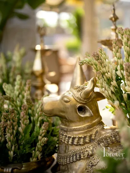 A brass Nandi statue, a sacred and traditional element, is beautifully integrated into the floral decor for a Muhurtham ceremony.