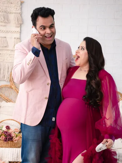 Who says pregnancy can't be fun? This playful shot captures a candid moment of laughter, with the dad-to-be on the phone sharing the exciting news.