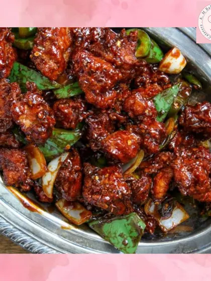A close-up of our spicy and tangy Chilli Chicken, a must-have from our Indo-Chinese menu. Each piece is coated in a flavourful sauce with fresh capsicum and onions, making it a perfect starter for parties.